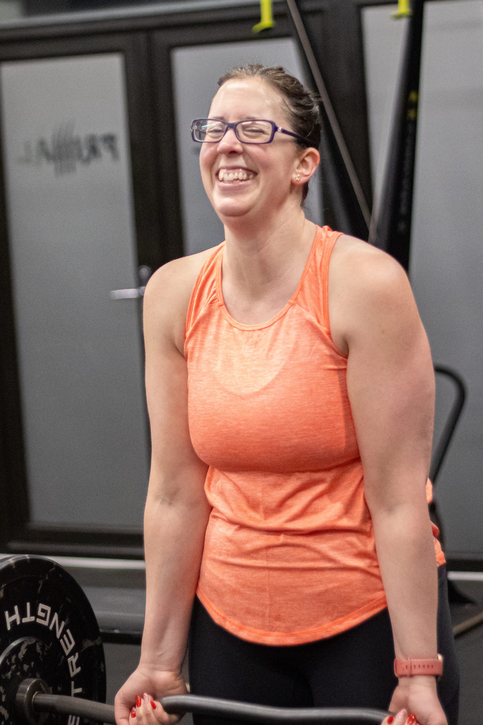 A Primal member laughing with a barbell