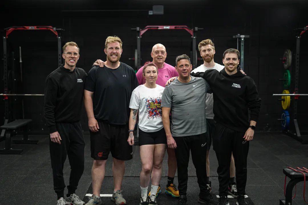 The Primal Fitness team and members in front of the red rigs